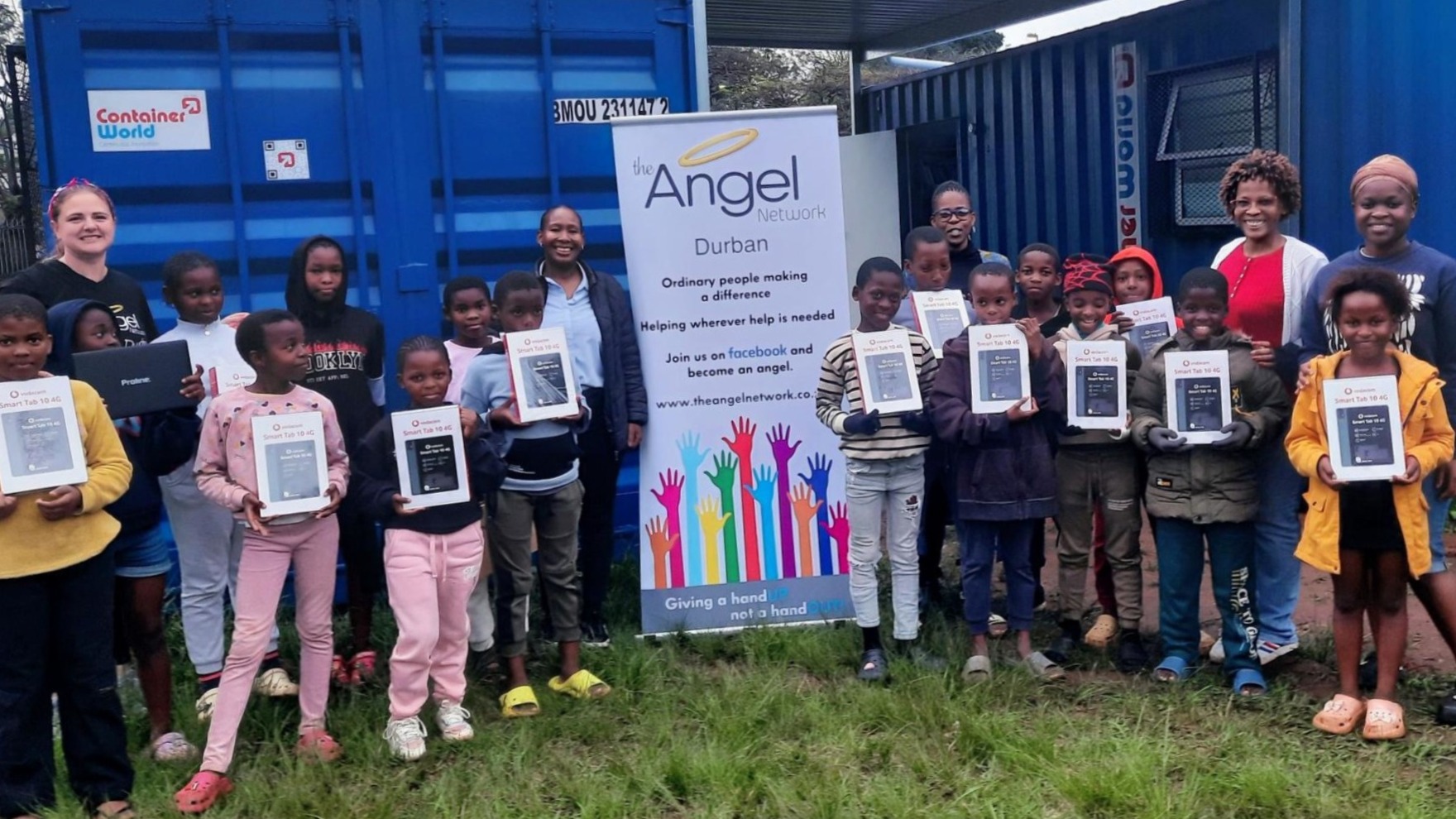 Children receiving tablets from Angel Network