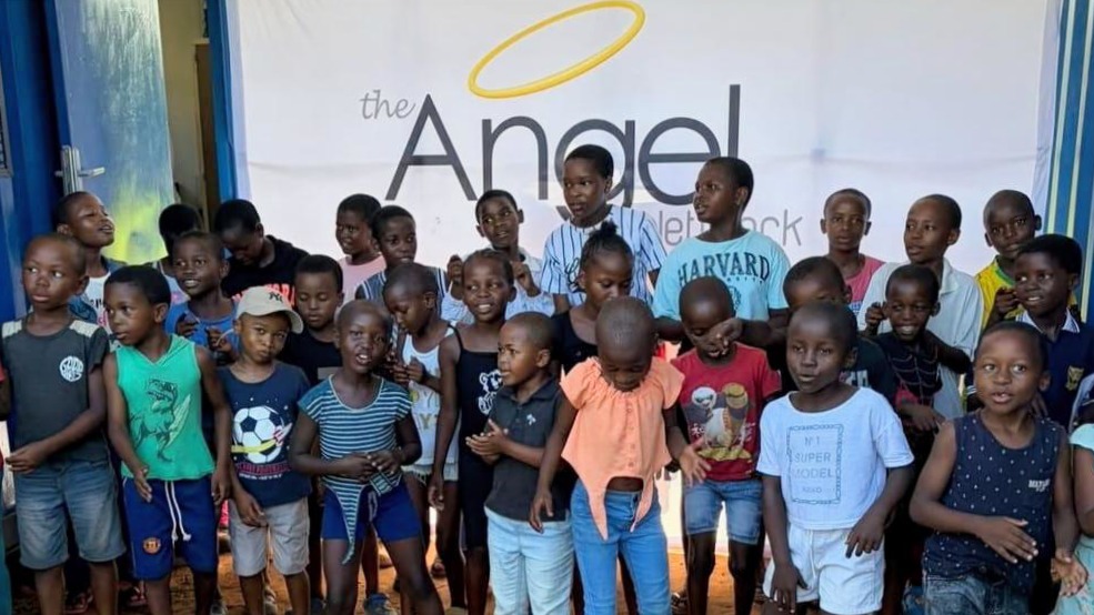 Large group of children with Angel Network banner